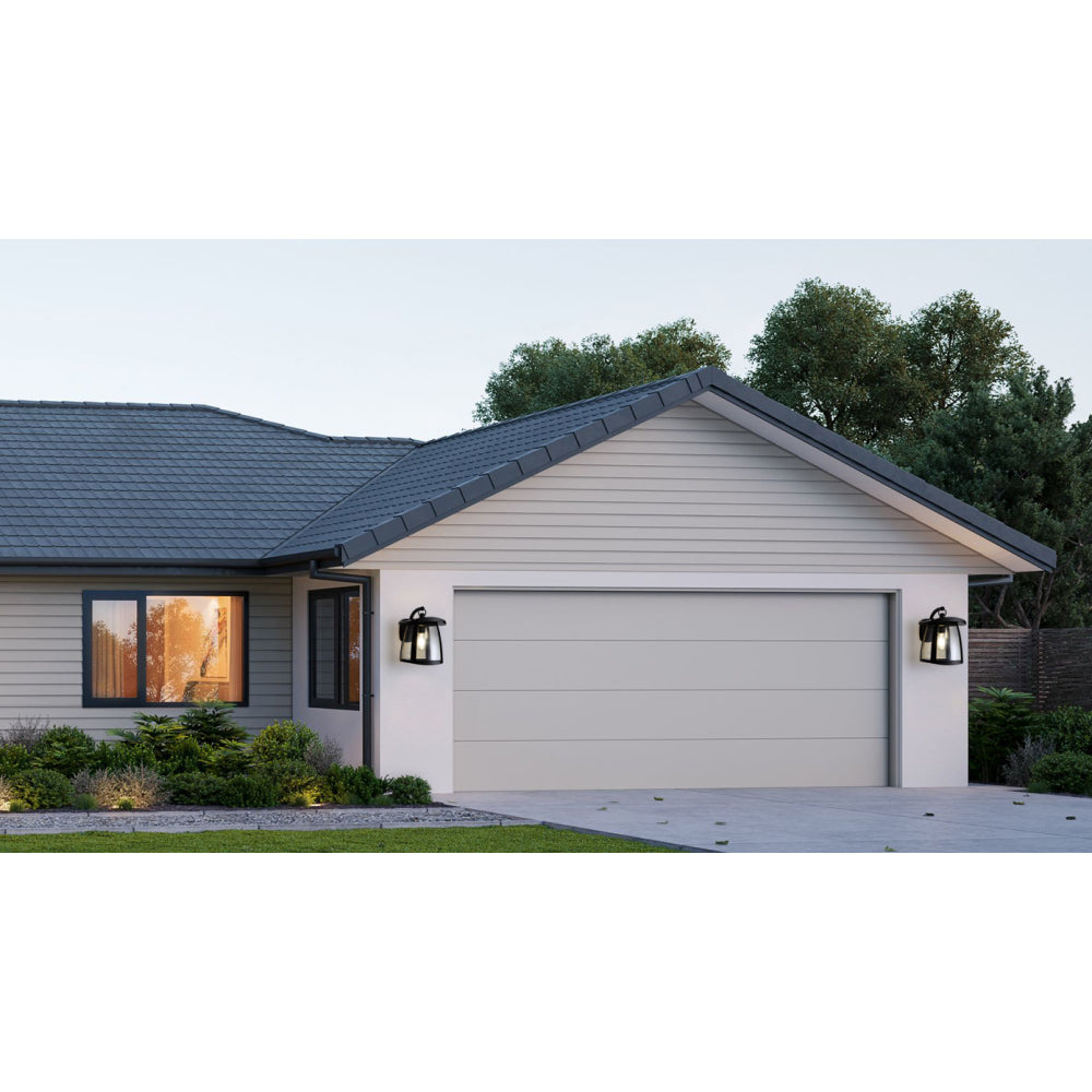 Solar wall lanterns with dual panels mounted on either side of a modern garage, providing outdoor home lighting.