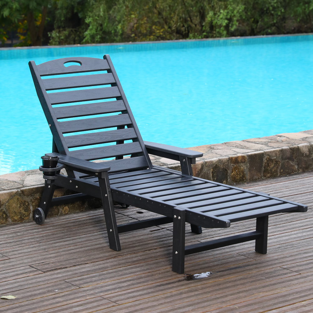 Black slatted reclining patio lounge chair with cup holder by poolside on wooden deck.