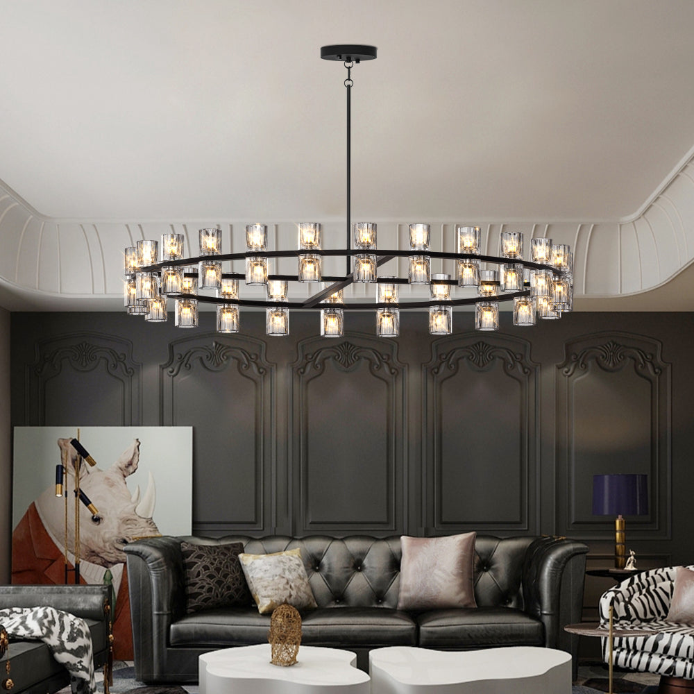 Large circular chandelier with multiple glass light fixtures, hanging above a tufted leather sofa in a sophisticated living room.