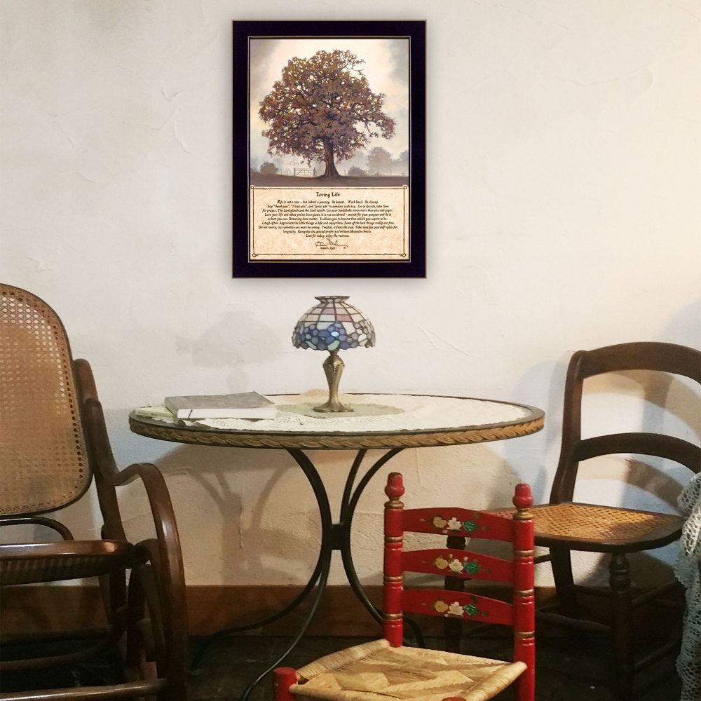 Framed art print of a large tree with poem, black frame, above a round table with stained glass lamp, surrounded by wooden and red floral chairs.
