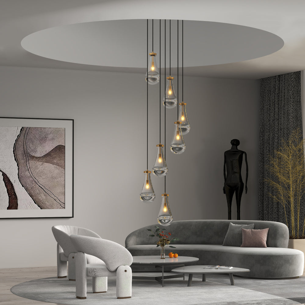 Gold 7-light raindrop cluster pendant chandelier illuminating a modern living room with gray sofa and abstract wall art