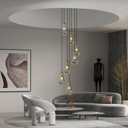 Gold 7-light raindrop cluster pendant chandelier illuminating a modern living room with gray sofa and abstract wall art