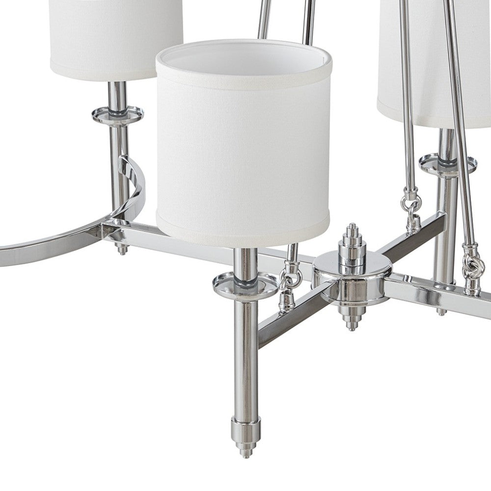 Close-up of Bedford Collection 6-light chandelier with chrome curved frame and white drum shades.