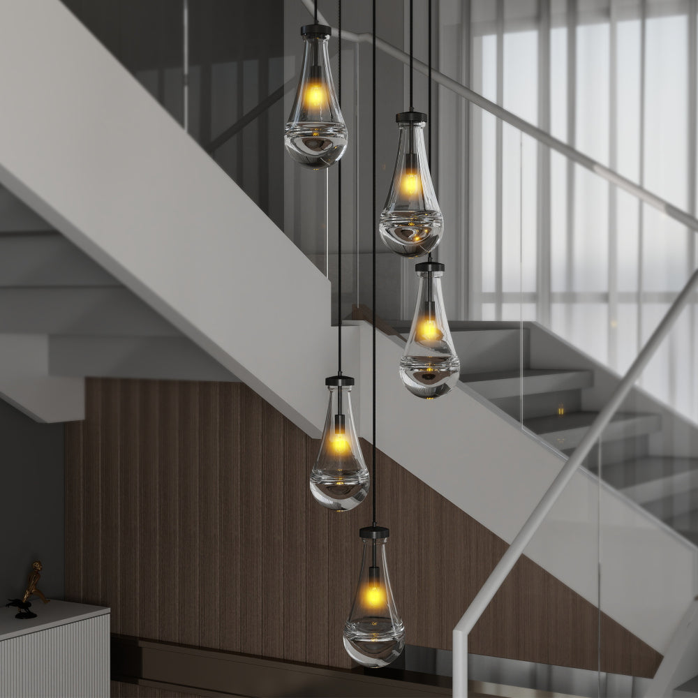 Black Raindrop Cluster Pendant Chandelier with 5 hand-blown glass pendants, hanging in a stairwell with white stairs and wooden paneling.