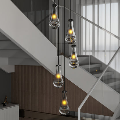 Black Raindrop Cluster Pendant Chandelier with 5 hand-blown glass pendants, hanging in a stairwell with white stairs and wooden paneling.