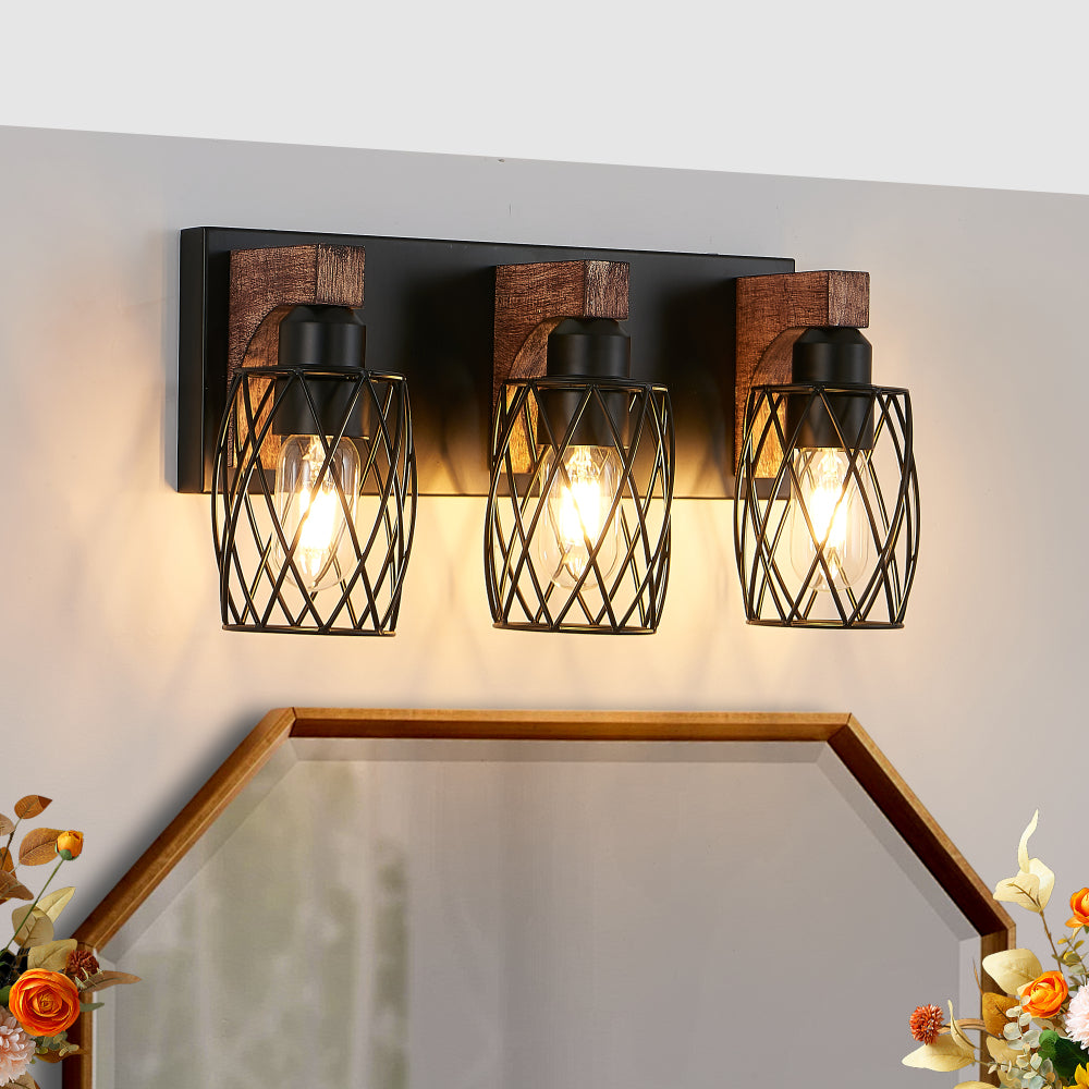 Industrial black metal cage wall sconce with wood accents, 3-light vintage fixture mounted above bathroom mirror with floral decor