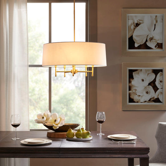 5-light drum shade chandelier with off-white cotton-linen shade and gold plated brass frame, hanging over dark wood dining table with plates, wine glasses, and floral centerpiece.