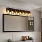 Industrial black cage wall sconce with wood accents, 7-light fixture mounted above large mirror, providing warm lighting for bathroom, hallway, or living room.