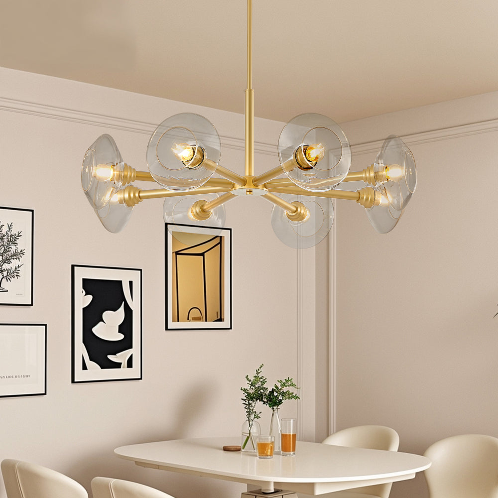 Gold mid-century modern sputnik chandelier with 8 clear glass shades over white dining table with framed art