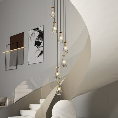 Gold 7-light raindrop cluster pendant chandelier hanging in a modern stairwell with curved walls and abstract art