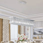 39.4-inch rectangle crystal raindrop chandelier with 8 lights, chrome finish, hanging over formal dining table with floral centerpiece