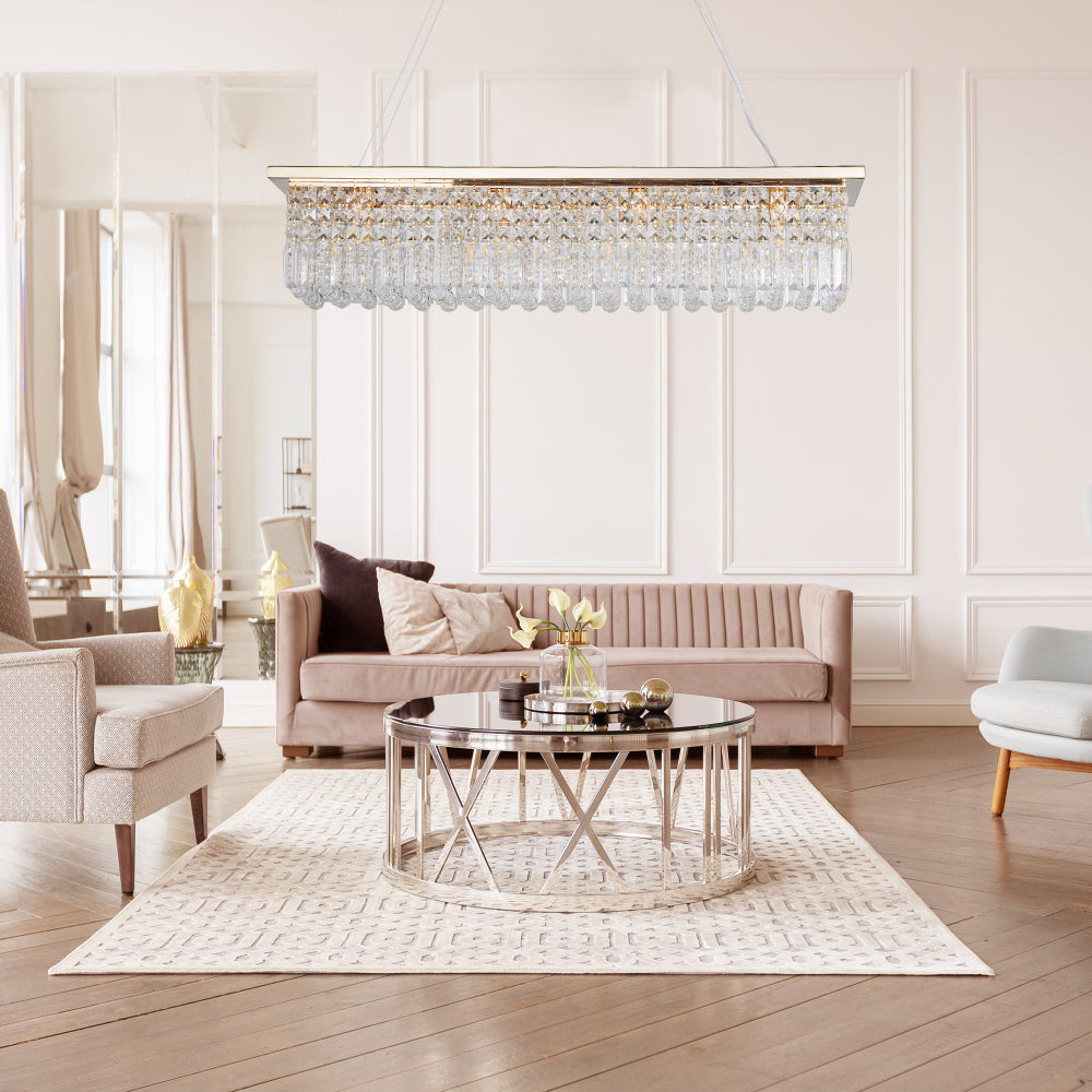 39.4-inch rectangle crystal raindrop chandelier with chrome finish, 8-light modern pendant for dining room or kitchen island, displayed in a living room with beige sofa and round glass coffee table.