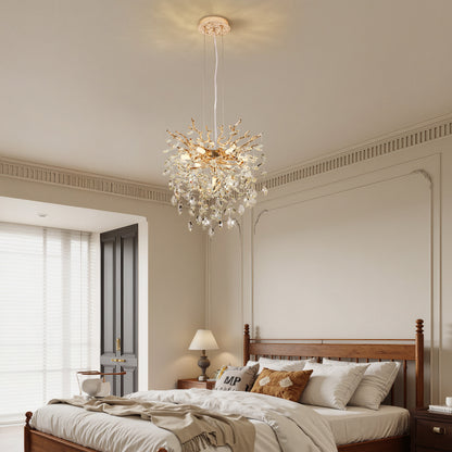 Gold tree branch crystal chandelier with sparkling crystal drops in a bedroom with wooden bed and neutral walls.
