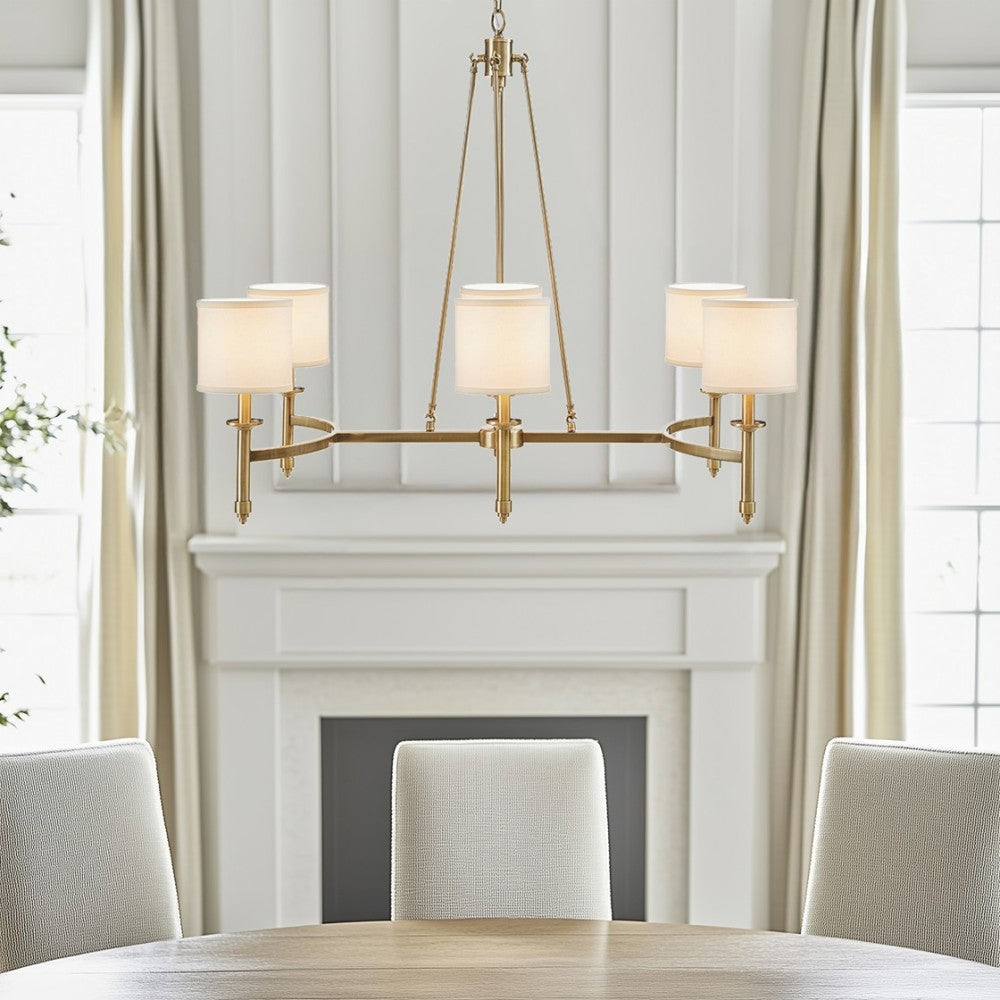 Gold 6-light drum shade chandelier with curved frame, transitional style, 39.25 inches wide, Bedford Collection, installed in dining room with fireplace and table.