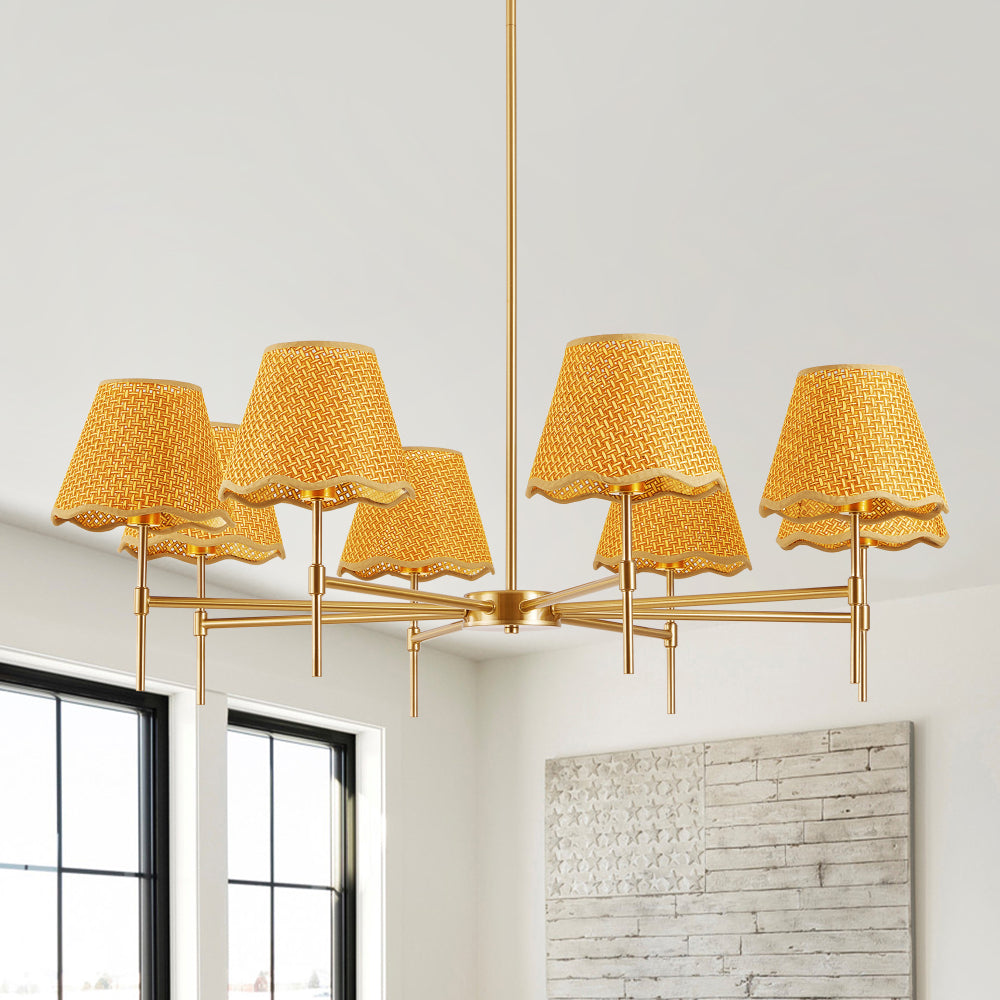 Gold Boho Rattan Chandelier with 8 yellow rattan lampshades hanging in a bright room with large windows and a textured brick wall.