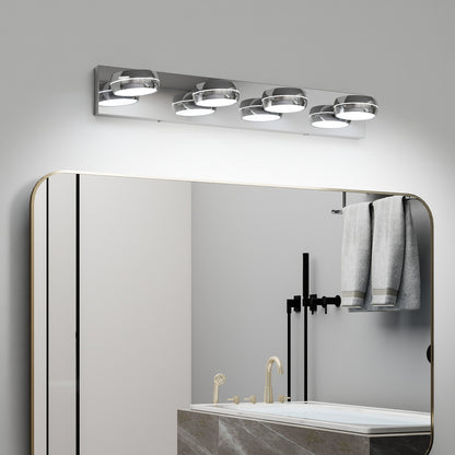Modern chrome 4-light LED vanity light bar, 28 inches, mounted above a gold-framed bathroom mirror with towels and fixtures below