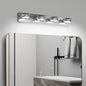 Modern chrome 4-light LED vanity light bar, 28 inches, mounted above a gold-framed bathroom mirror with towels and fixtures below