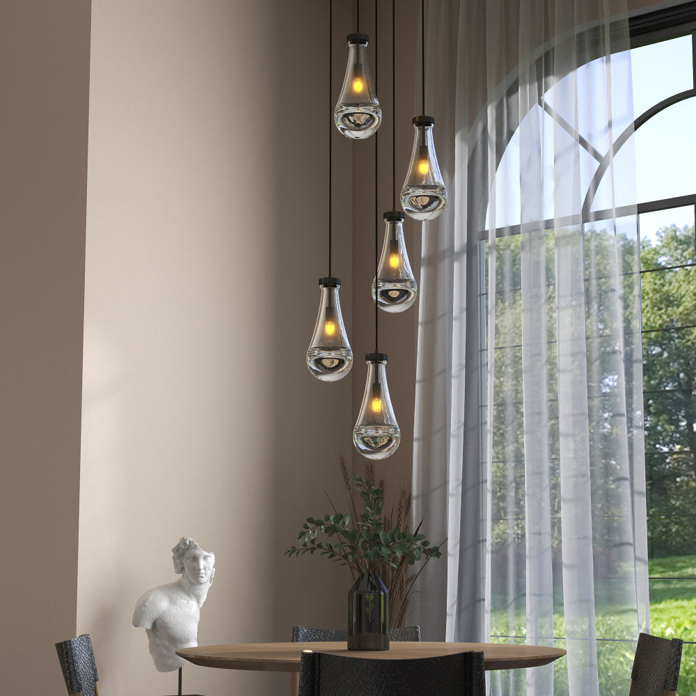 Raindrop Cluster Pendant Chandelier with 5 hand-blown glass raindrop pendants, black cord, adjustable length, in a dining room with large arched window and wooden table.