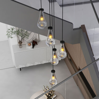 Raindrop cluster pendant chandelier with hand-blown glass drops, warm illumination, hanging in a modern living space with a white cabinet and wooden elements.