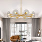 Gold mid-century modern sputnik chandelier with 8 clear glass shades in a living room with gray curtains and brown armchair