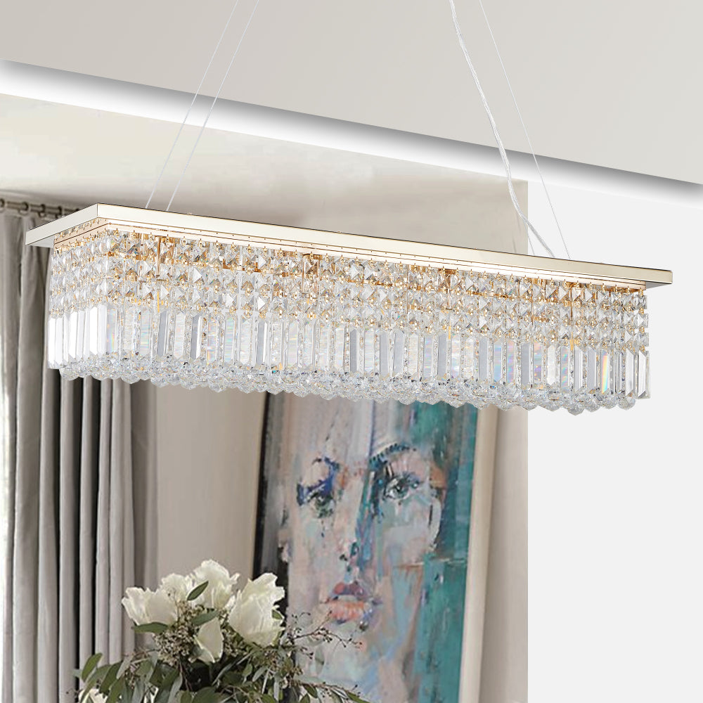 39.4-inch rectangle crystal raindrop chandelier with gold finish, 8-light modern pendant for dining room or kitchen island, hanging in a dining room with gray curtains, white flowers, and abstract painting.