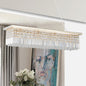 39.4-inch rectangle crystal raindrop chandelier with gold finish, 8-light modern pendant for dining room or kitchen island, hanging in a dining room with gray curtains, white flowers, and abstract painting.