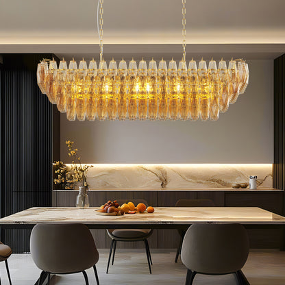 Gold Tiered Smoke Glass Chandelier, 12-light rectangular, hanging in a modern kitchen with marble table and fruit bowl.
