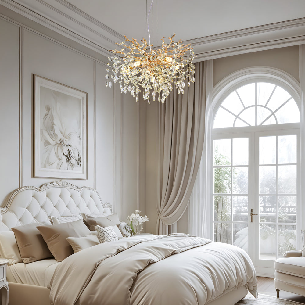 Gold Tree Branch Crystal Chandelier with gold branches and crystal accents, hanging in a bedroom with tufted headboard and large arched windows.