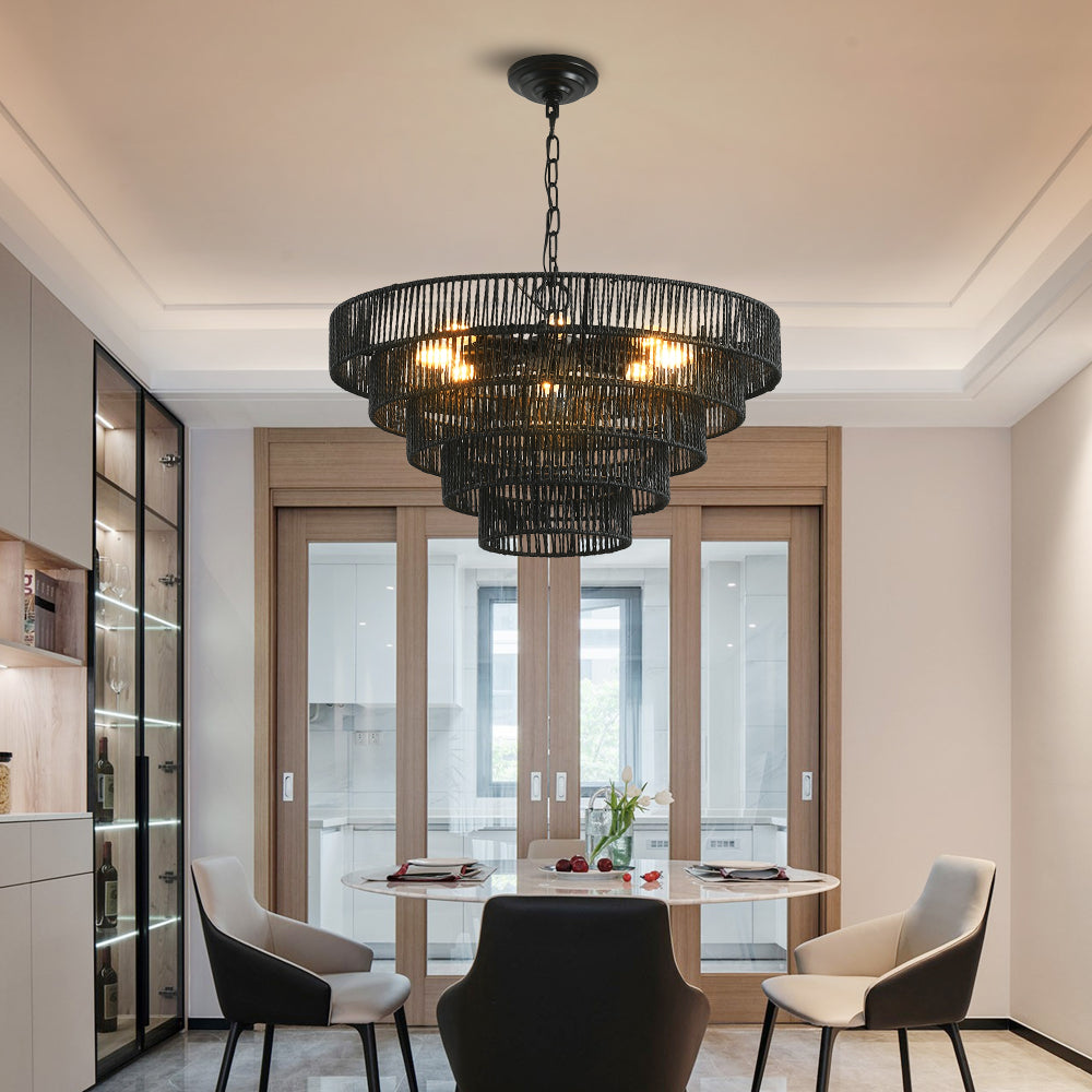 5-tier black hemp rope chandelier with lit E12 bulbs, hanging above a round dining table with modern chairs in a dining room.