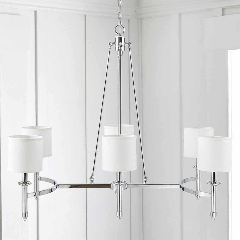 Bedford Collection 6-light chandelier with chrome curved frame and white drum shades hanging in a bright room with white paneling.