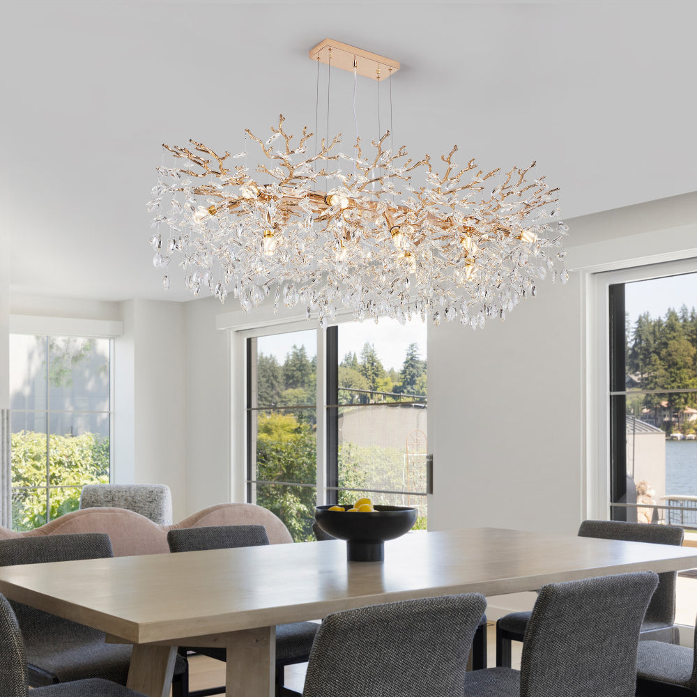 Gold Tree Branch Crystal Chandelier with gold branches and crystal accents, hanging in a bright dining room with large windows and natural light.