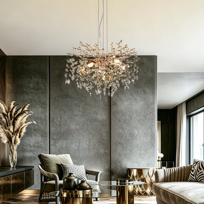 Gold tree branch crystal chandelier with sparkling crystal drops hanging in a modern living room with gray walls and contemporary furniture.