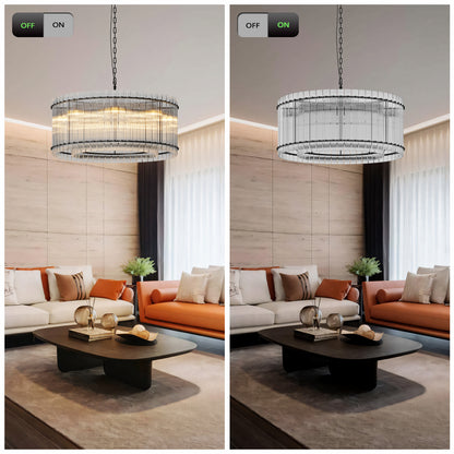 Modern round crystal glass chandelier with warm illumination on, hanging in a living room with orange and white sofas, dark coffee table, and light wood walls.