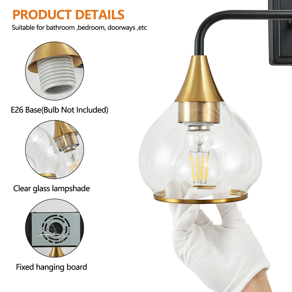 Close-up of black and gold vanity wall sconce with clear glass lampshade, E26 base (bulb not included), and fixed hanging board.