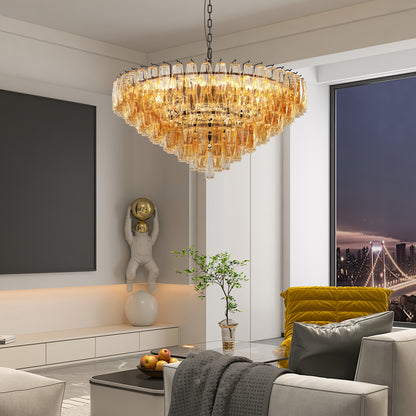 Round tiered smoke glass chandelier with gold metal frame, 14 lights, 37 inches wide, dimmable, in a modern living room with yellow accent pillows and city view
