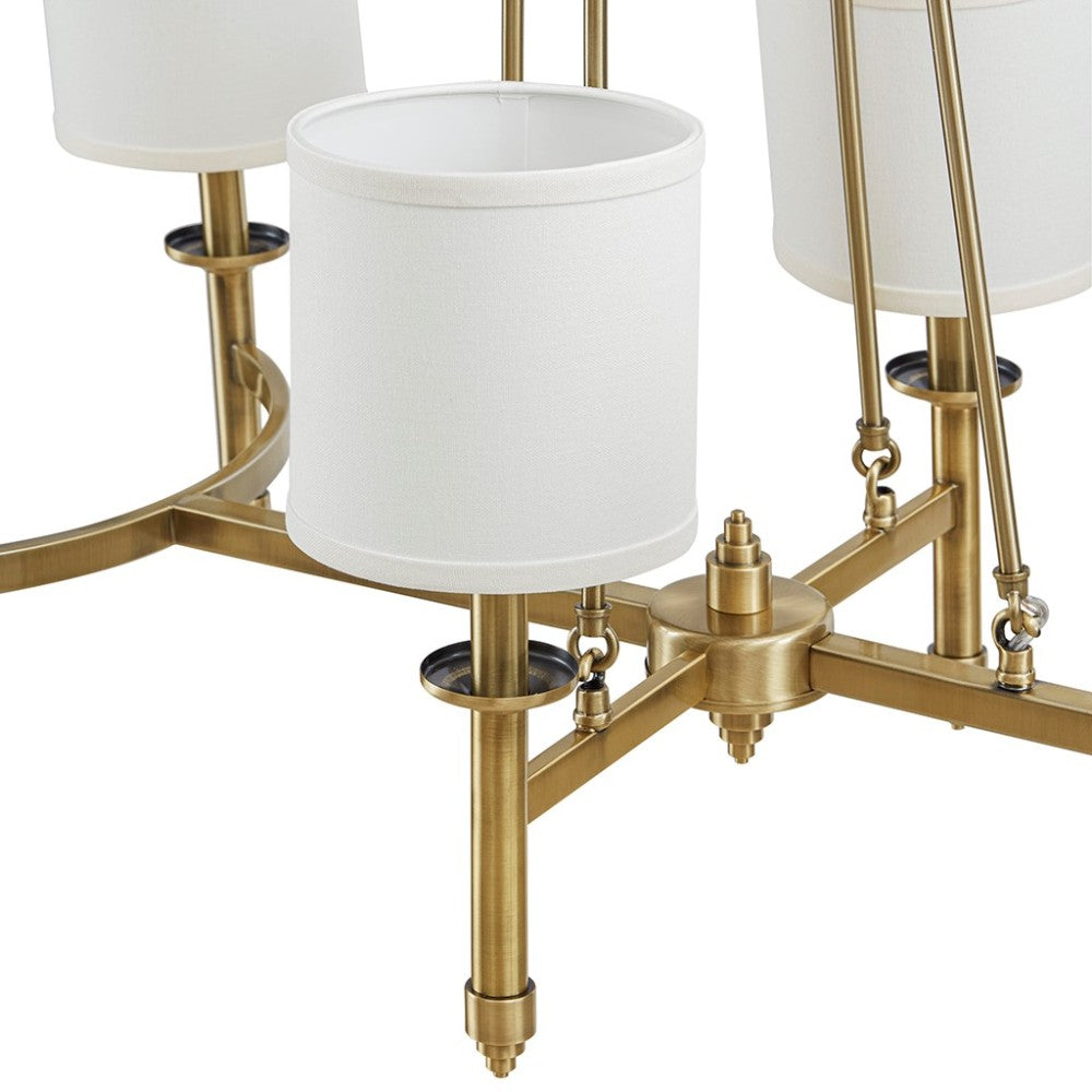 Close-up of Bedford Collection 6-light chandelier with gold curved frame and white drum shades.