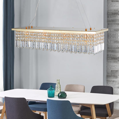 39.4-inch rectangle crystal raindrop chandelier with gold finish, 8-light modern pendant for dining room or kitchen island, hanging over a white dining table with blue and gray chairs.