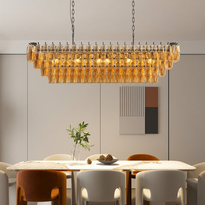 Rectangular tiered chandelier with black metal frame and amber smoke glass, 12-light design, 54" size, above marble dining table.
