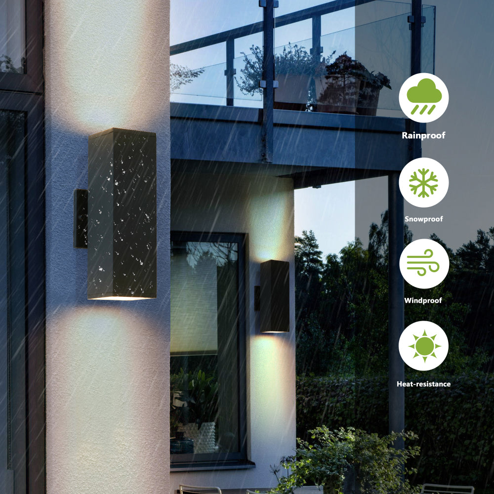 Modern black outdoor wall sconce with up & down lighting, shown in rain with weatherproof features (rainproof, snowproof, windproof, heat-resistant) mounted on house exterior.